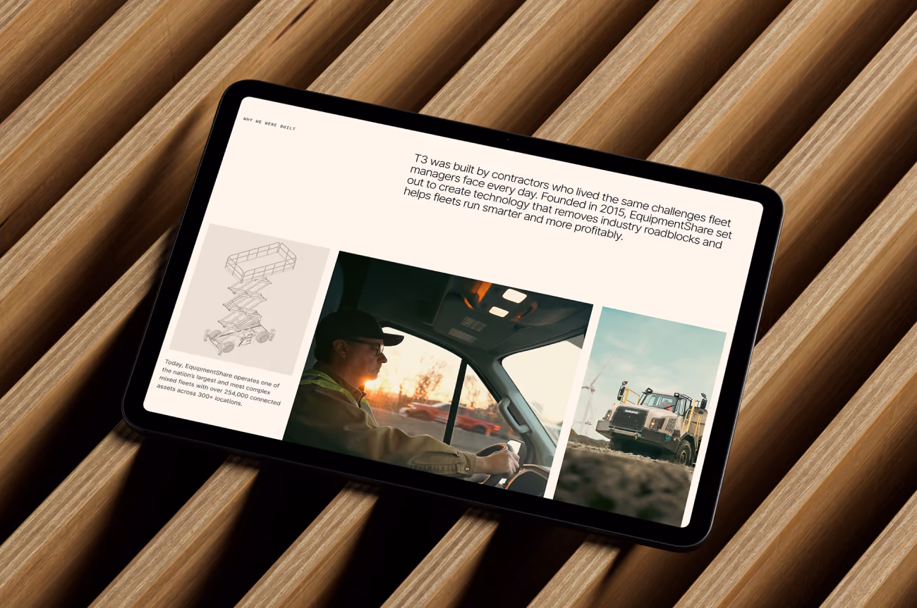 Tablet on ribbed wood showing a T3 fleet technology page with photos of a truck driver and heavy equipment.