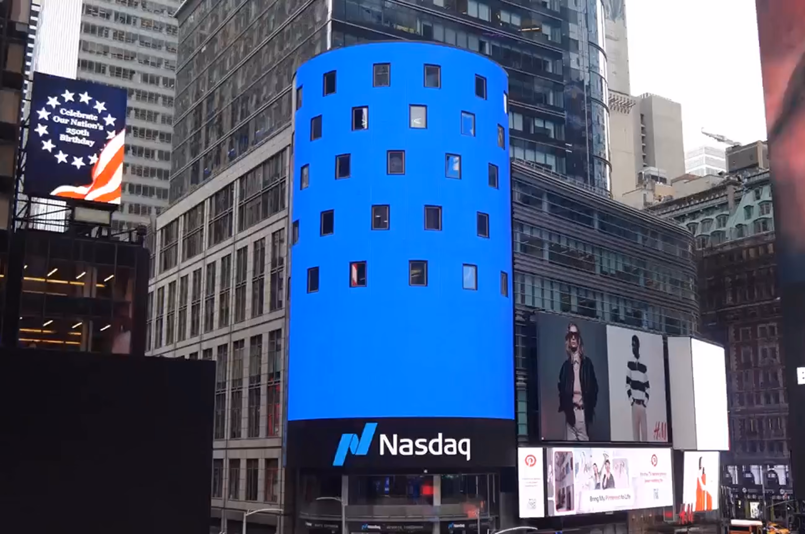 The Nasdaq tower in Times Square wrapped in a solid bright-blue display.