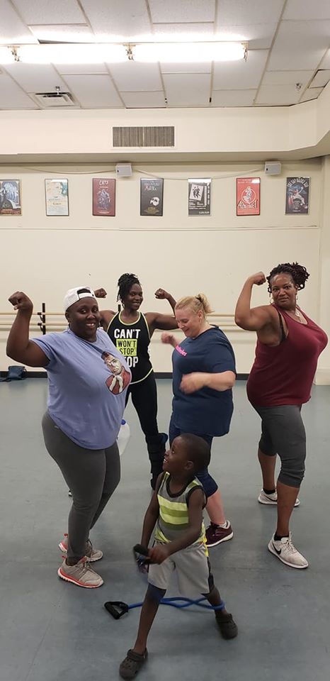 Community members posing together after a fitness class at Auburn Public Theater