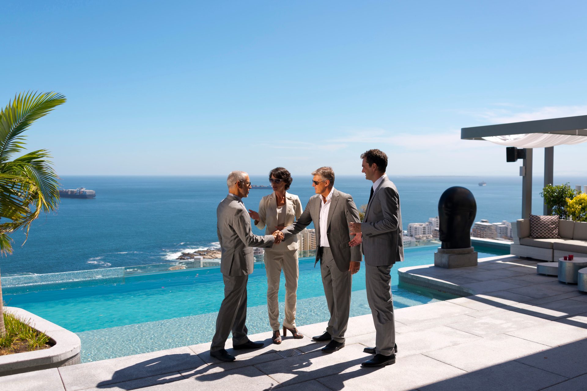 Business executives shaking hands on an oceanfront terrace