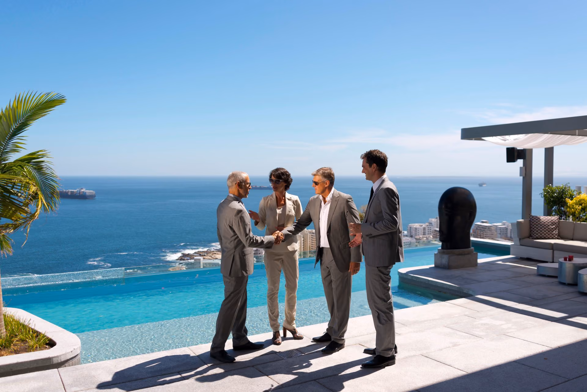 Business executives shaking hands on an oceanfront terrace