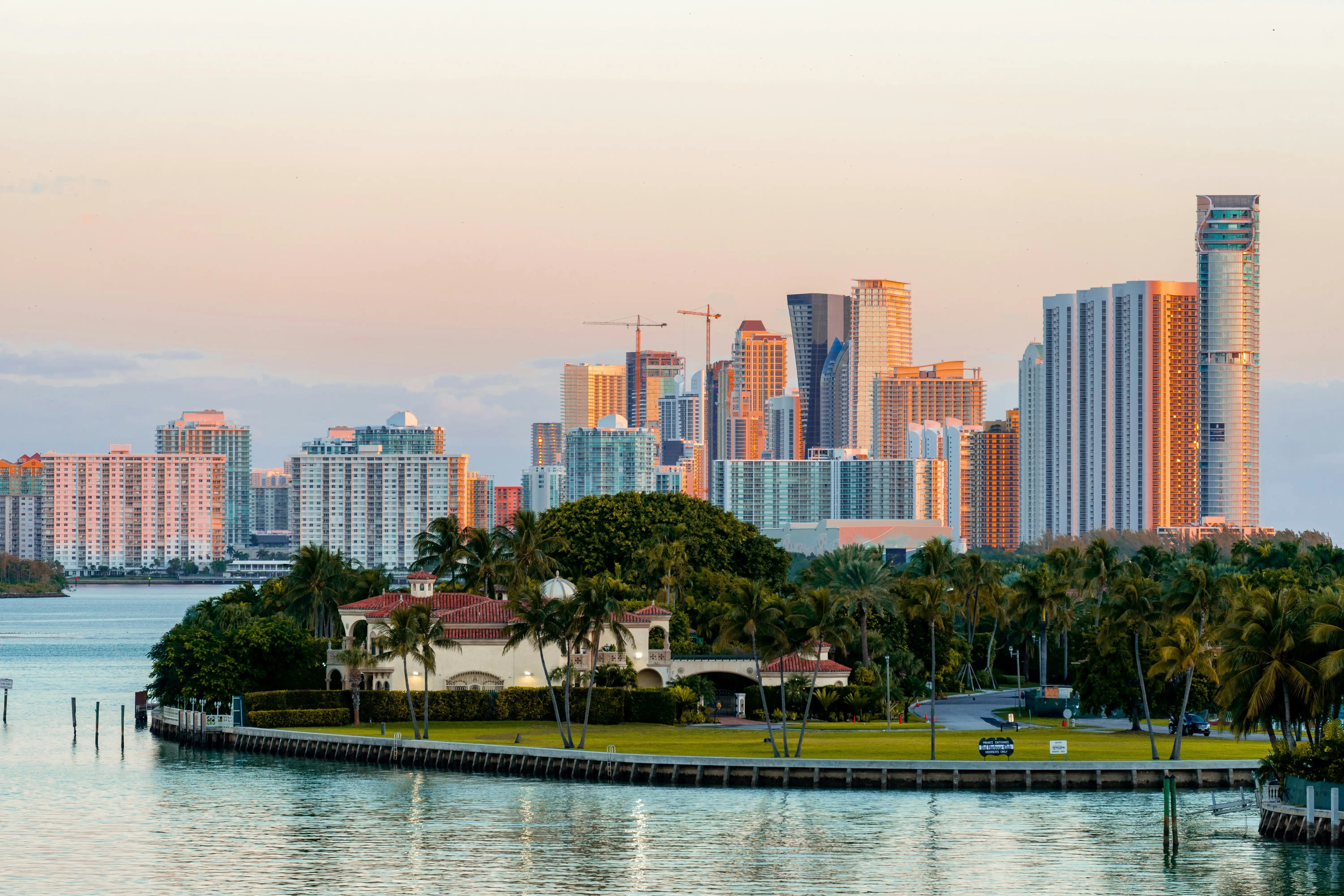 Waterfront homes and high-rise skyline in South Florida at sunset