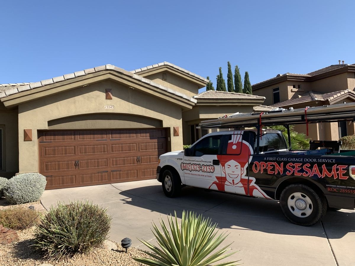 Open Sesame service truck at a home with a woodgrain garage door