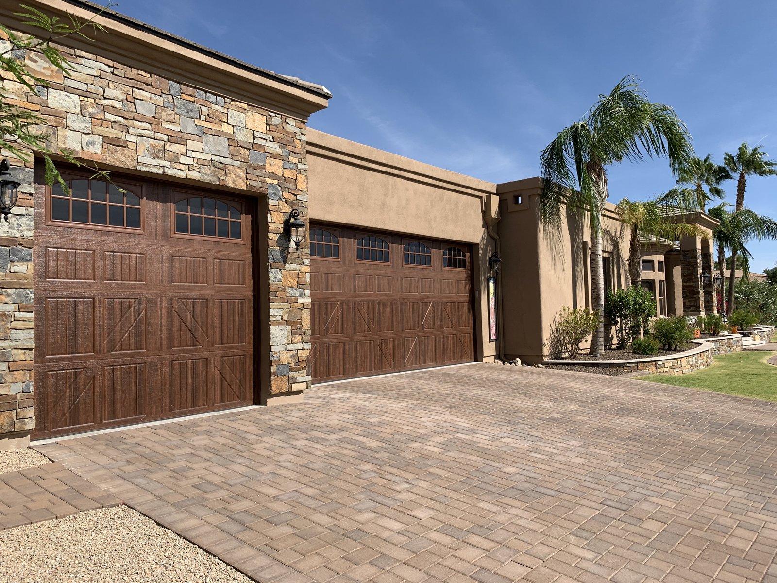 Two woodgrain garage doors on a stone and stucco Phoenix home