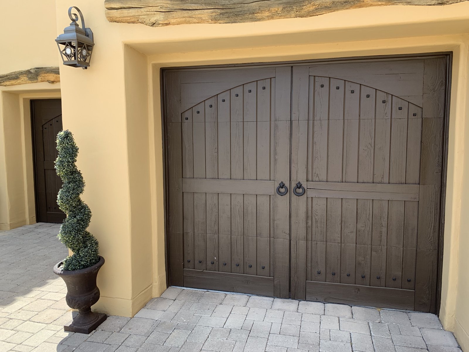 Carriage style garage door in a stucco courtyard entry