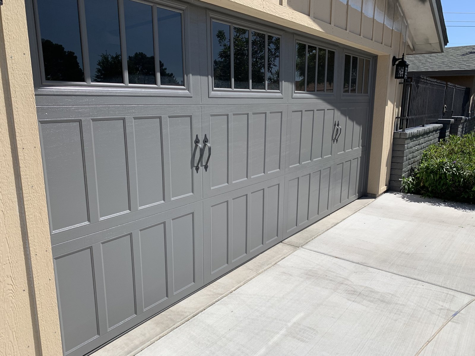 Grey panelled garage door with a row of top windows