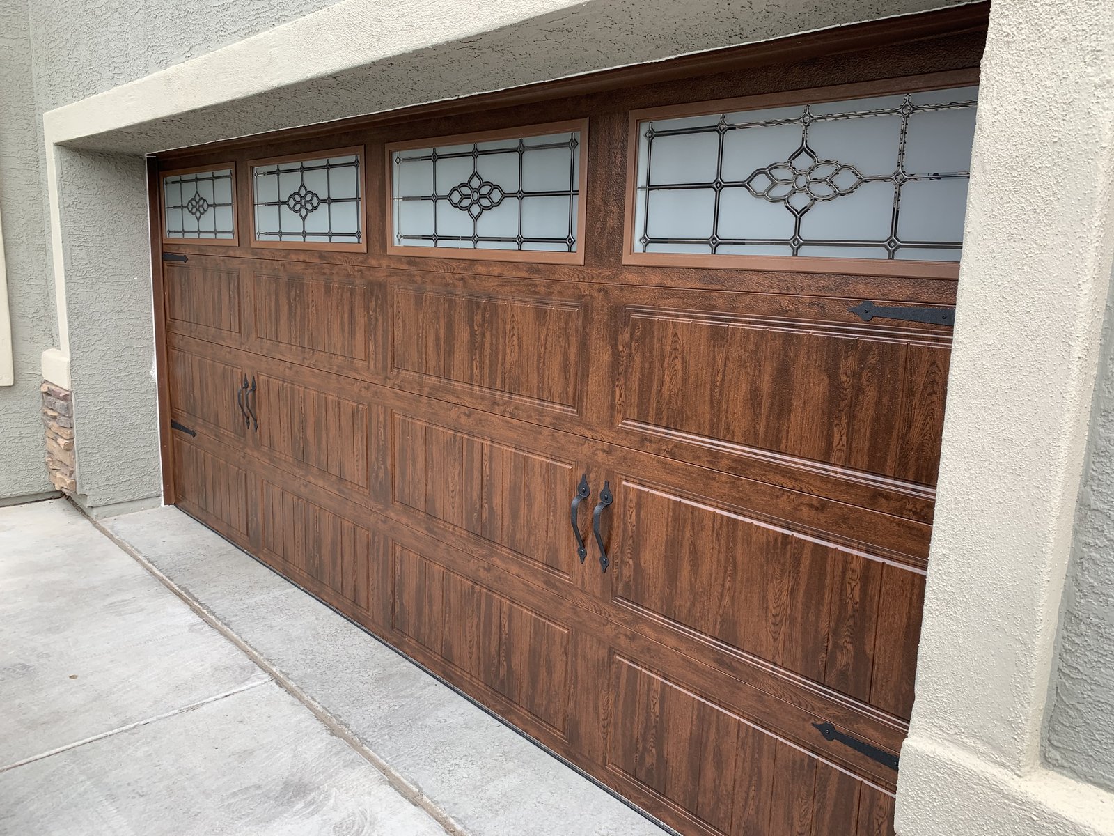 Woodgrain garage door with decorative leaded glass panels
