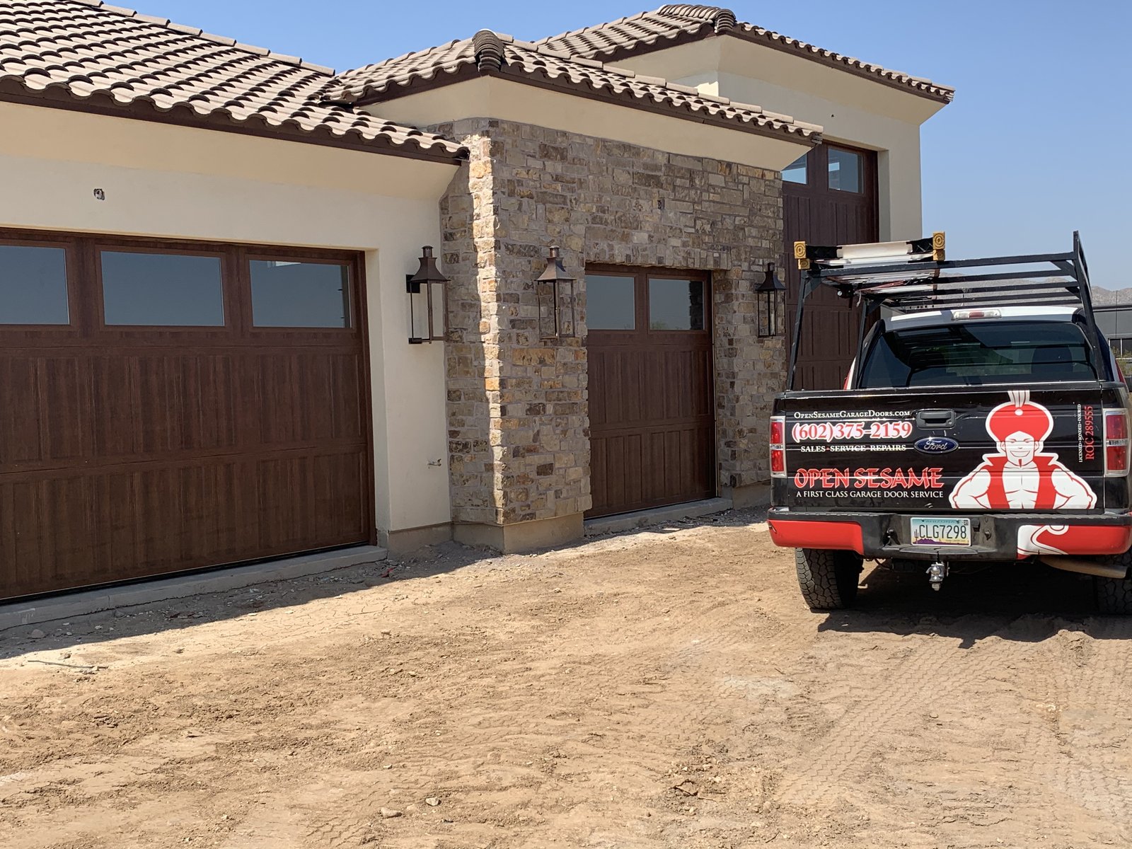 Open Sesame truck outside a stone fronted home with woodgrain doors