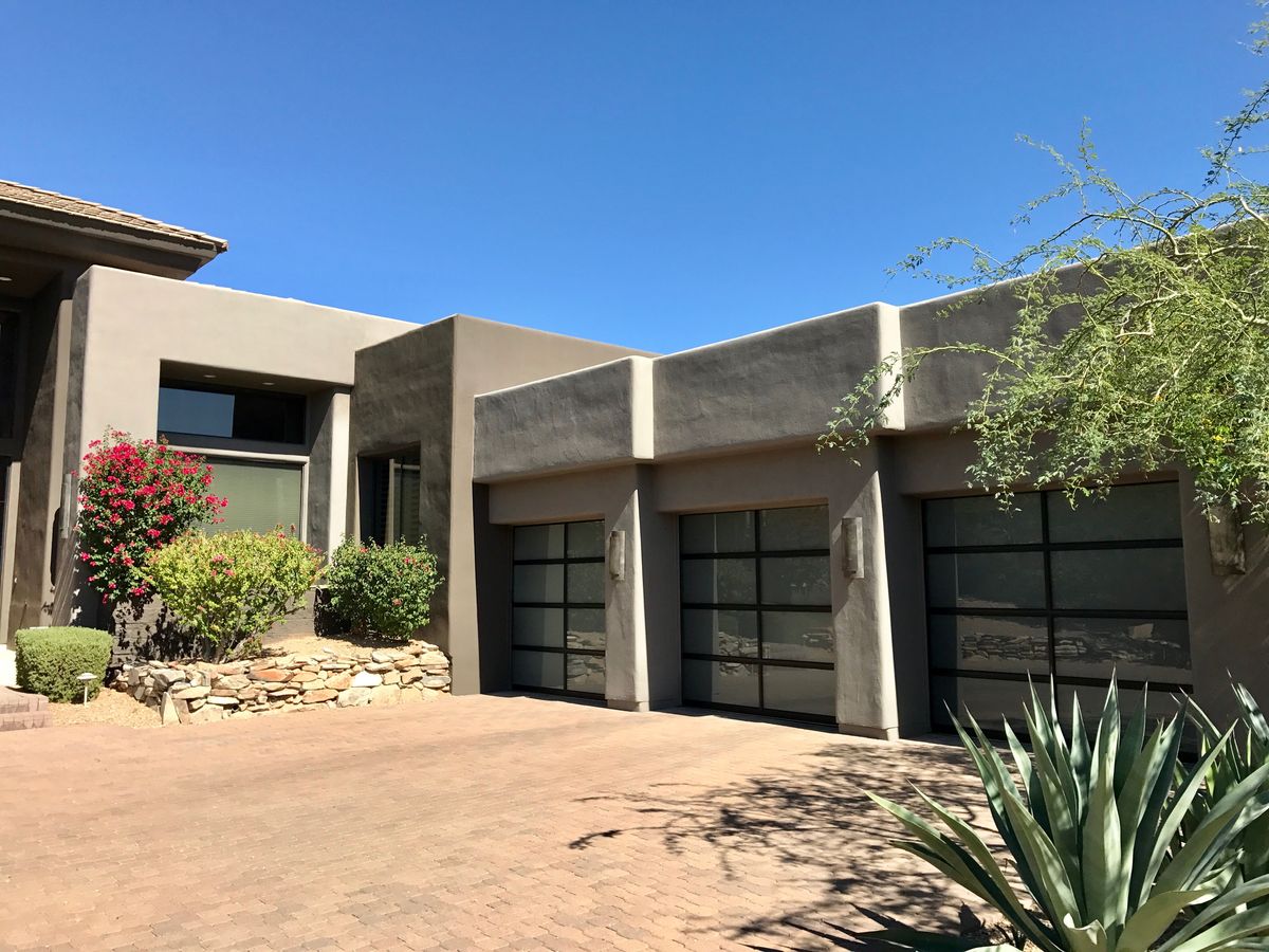 Modern glass and metal garage doors on a desert home
