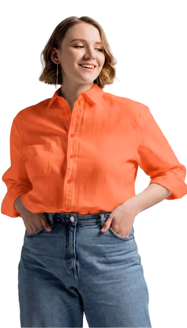 Smiling woman wearing an orange button-up shirt and blue jeans with hands in pockets.
