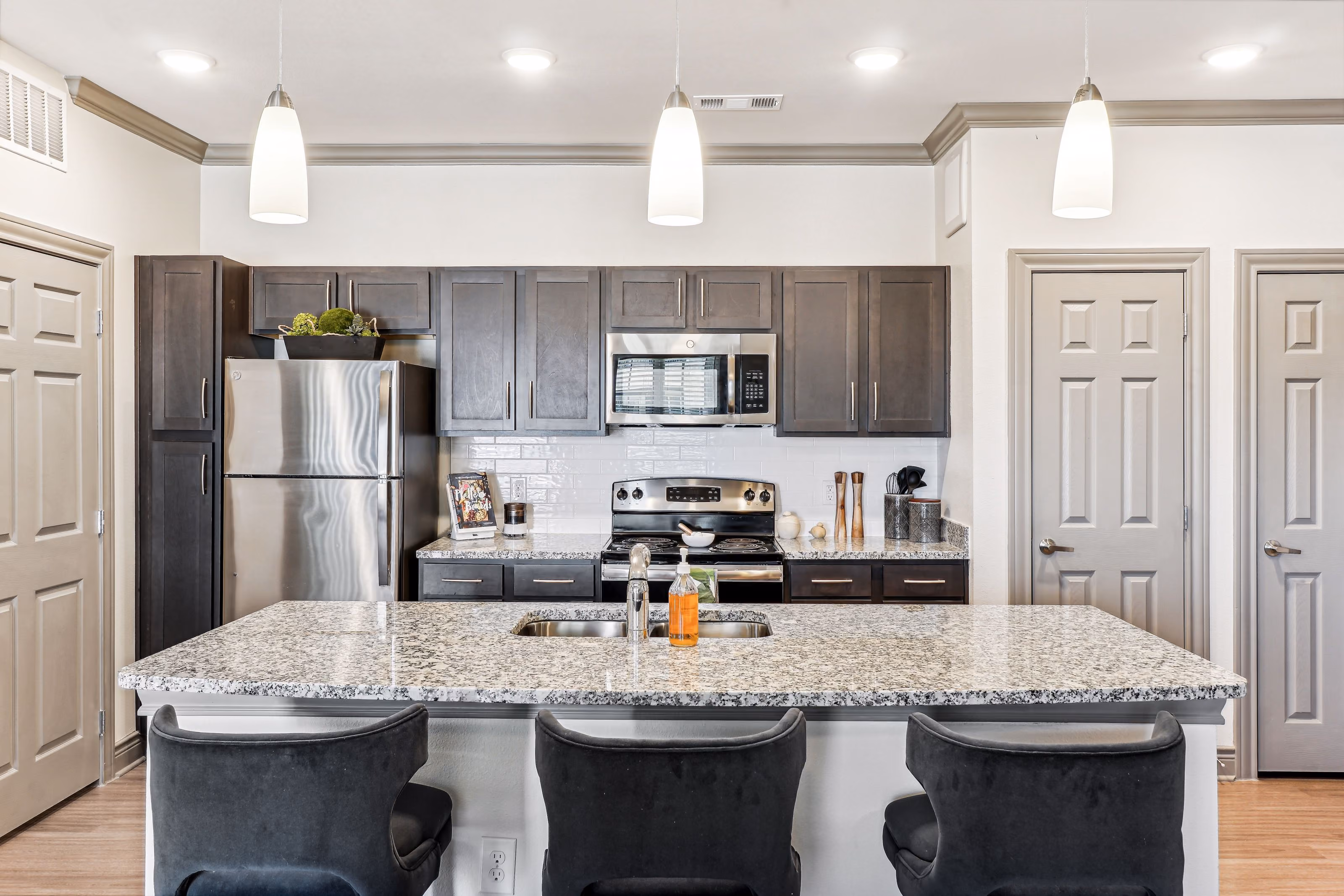 Kitchen with island, chairs, and stainless steel appliances