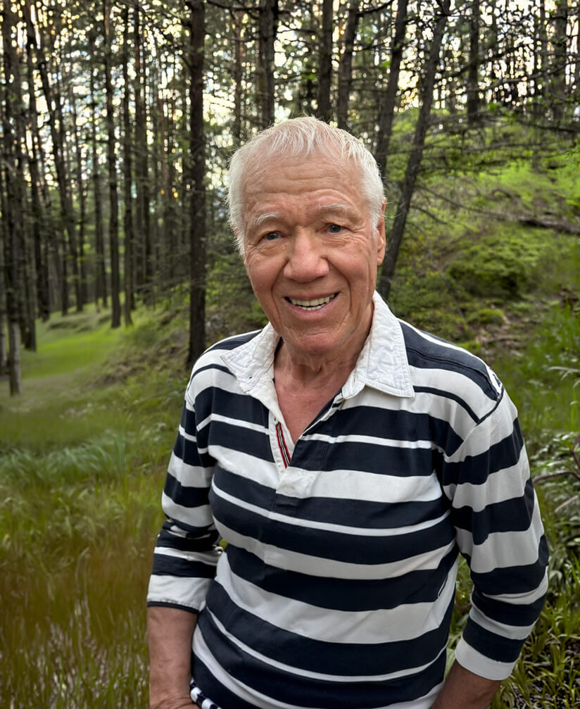 A photo of Lou Sherman standing in a forest.