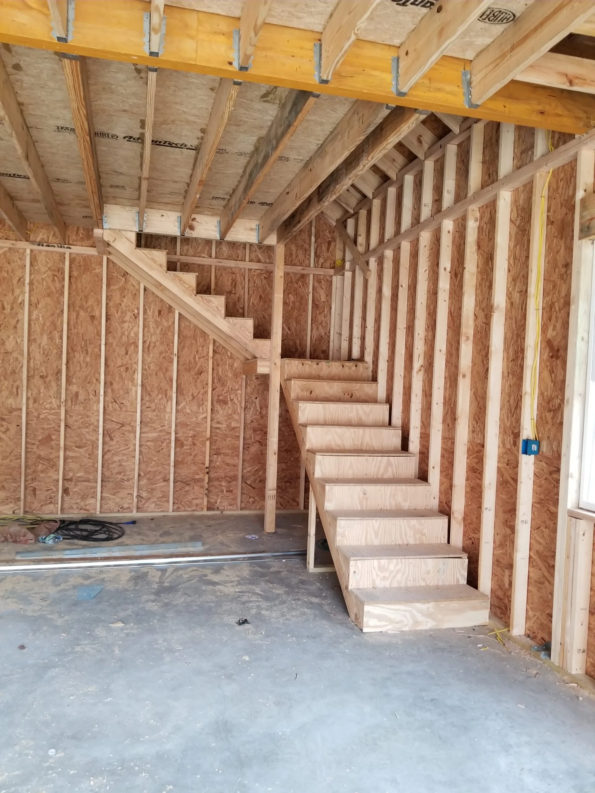 Interior wood framing and a new staircase inside the detached garage build