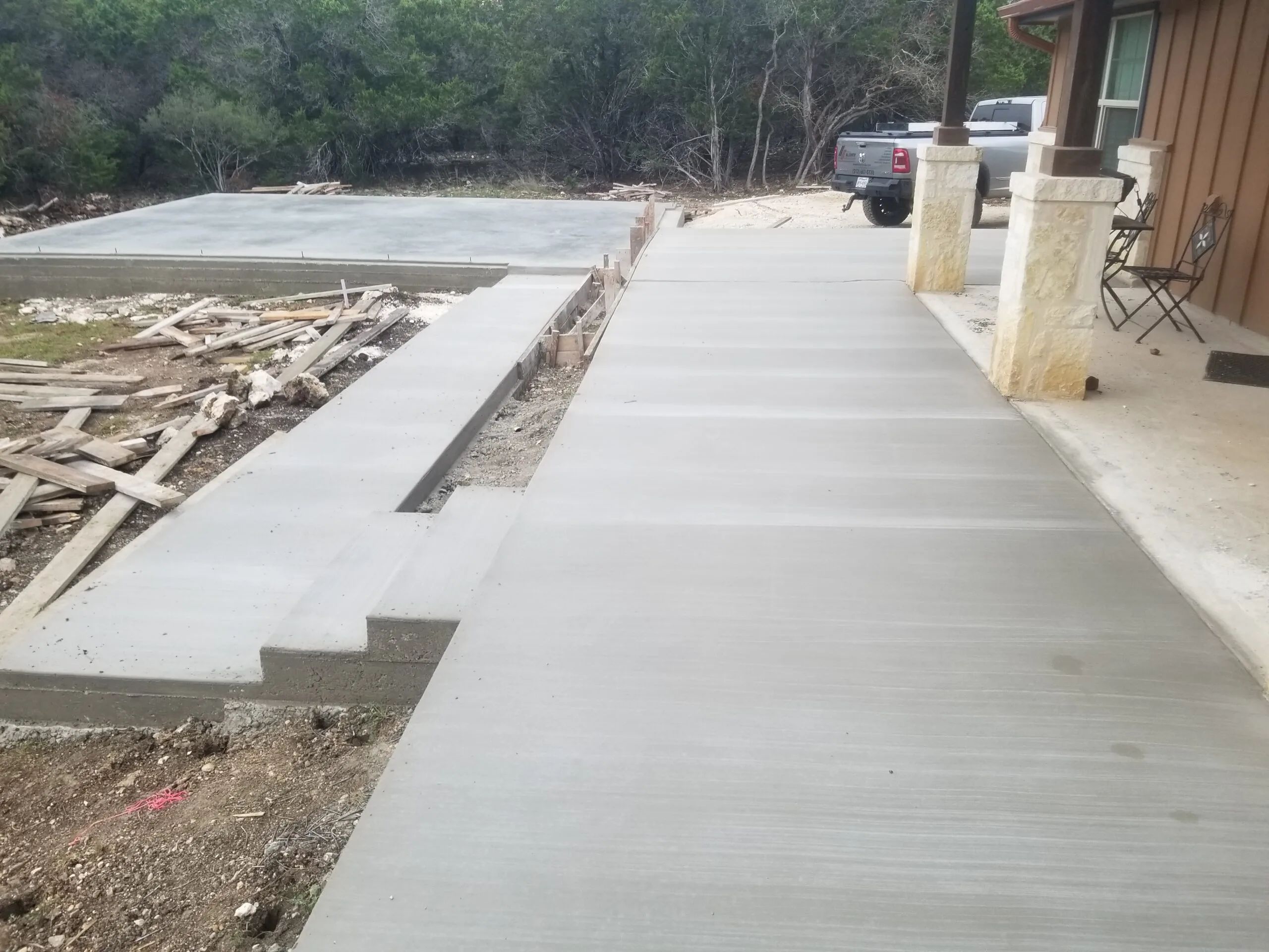 Newly poured concrete driveway and steps alongside the finished garage