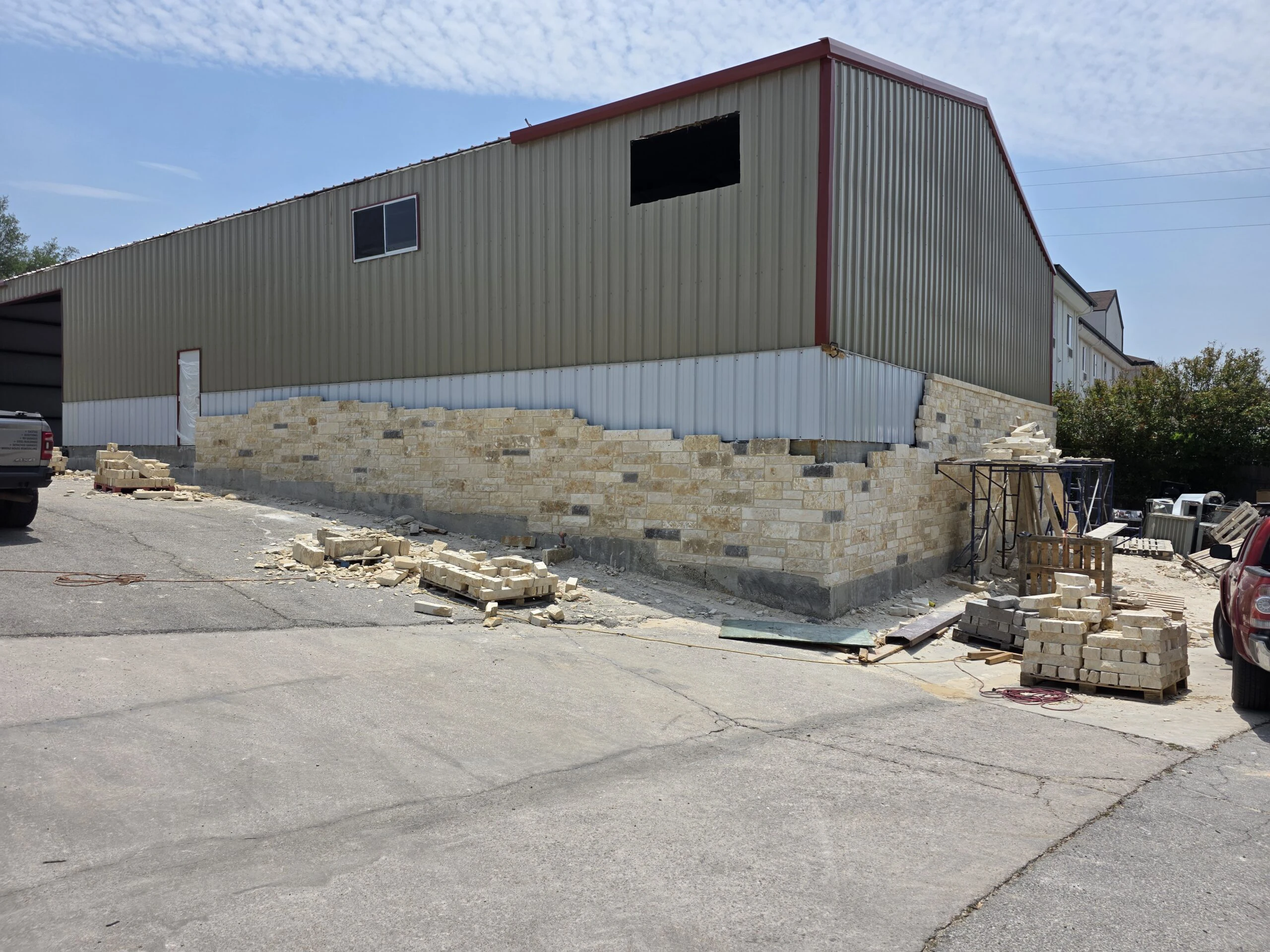 Commercial metal warehouse with limestone wainscot being installed