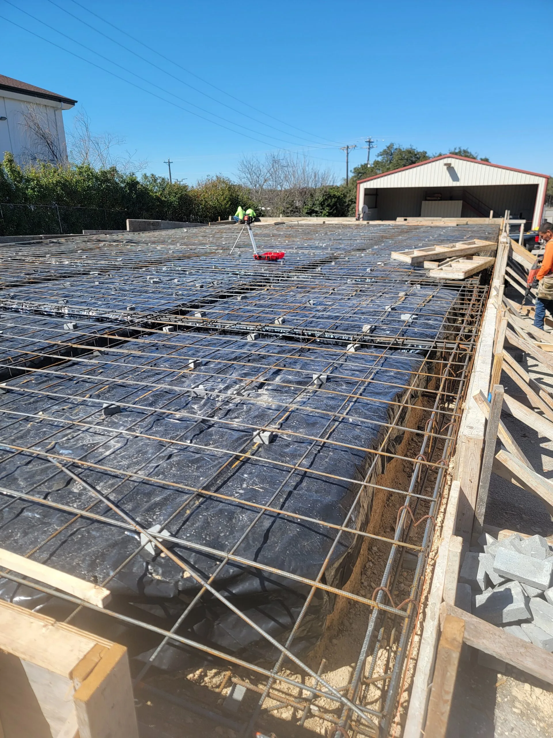 Rebar and vapor barrier laid out over the pad before the slab pour