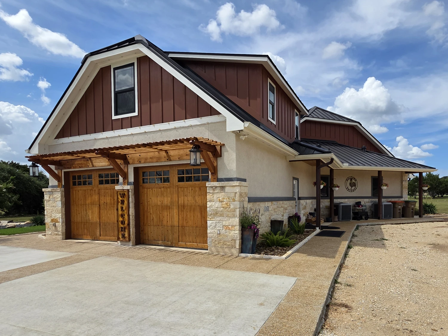 Attached garage with cedar carriage doors and a timber pergola over the driveway