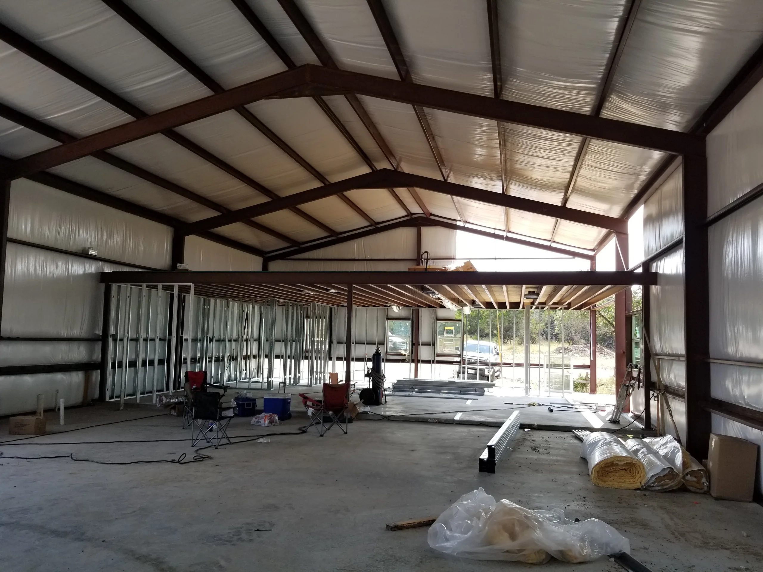 Dried-in interior with metal stud partitions framed under the exposed steel rafters