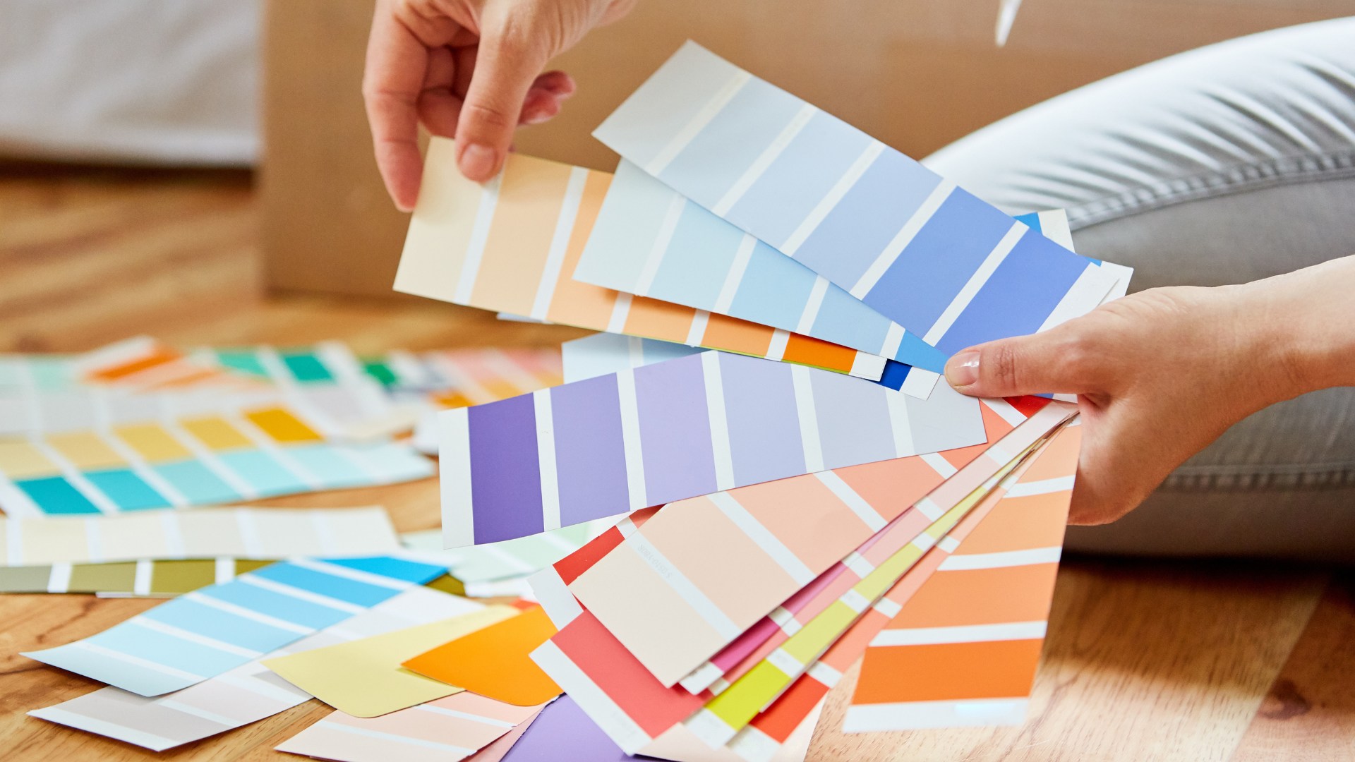 Homeowner comparing interior paint color swatches before a painting project