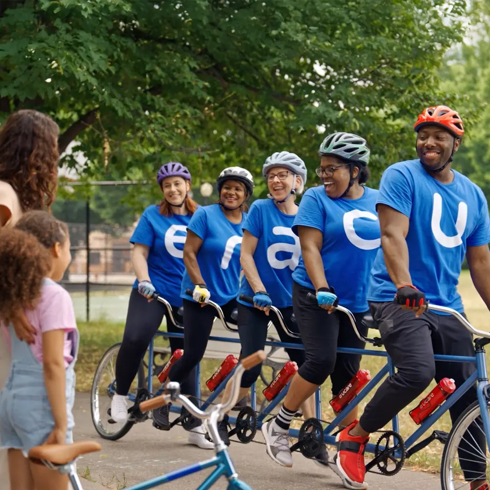 UCare team members riding on a 5 person bike.