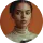 Portrait of a young woman with dark hair pulled back, wearing a white top and hoop earrings, looking directly at the camera.