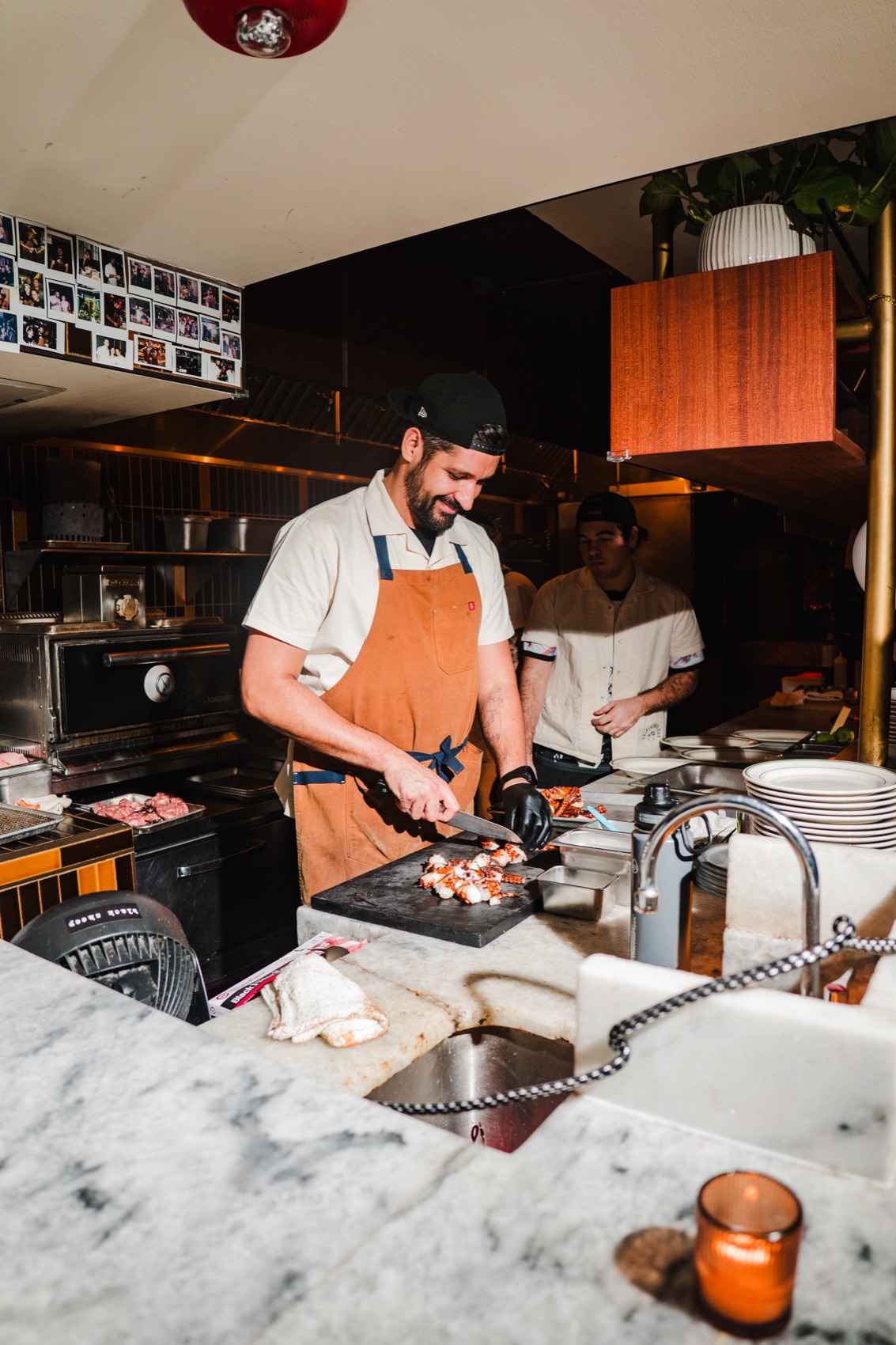 CANA cook smiling while preparing food in the open kitchen