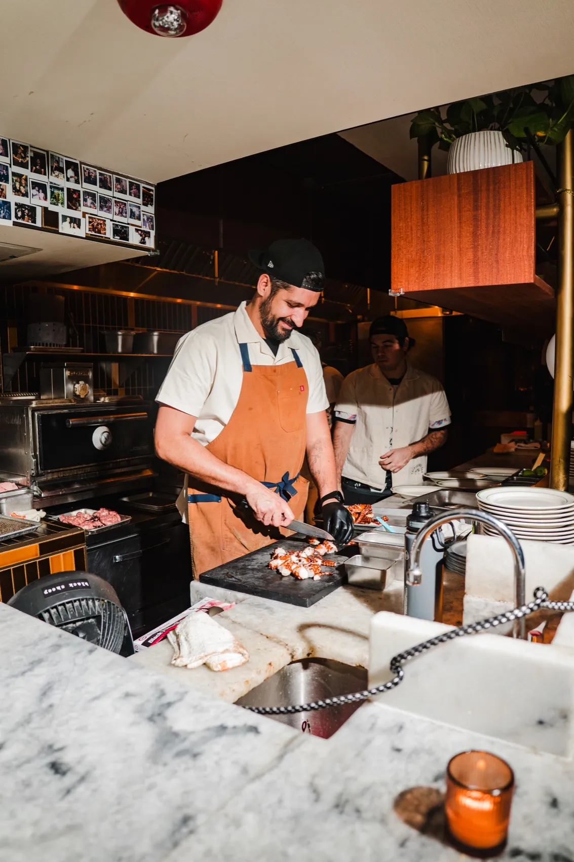 CANA cook smiling while preparing food in the open kitchen
