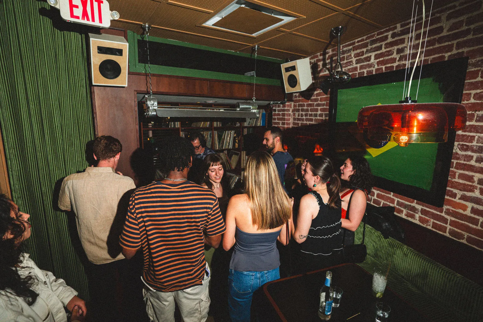Guests gathered around CANA's record booth beneath a Brazilian flag