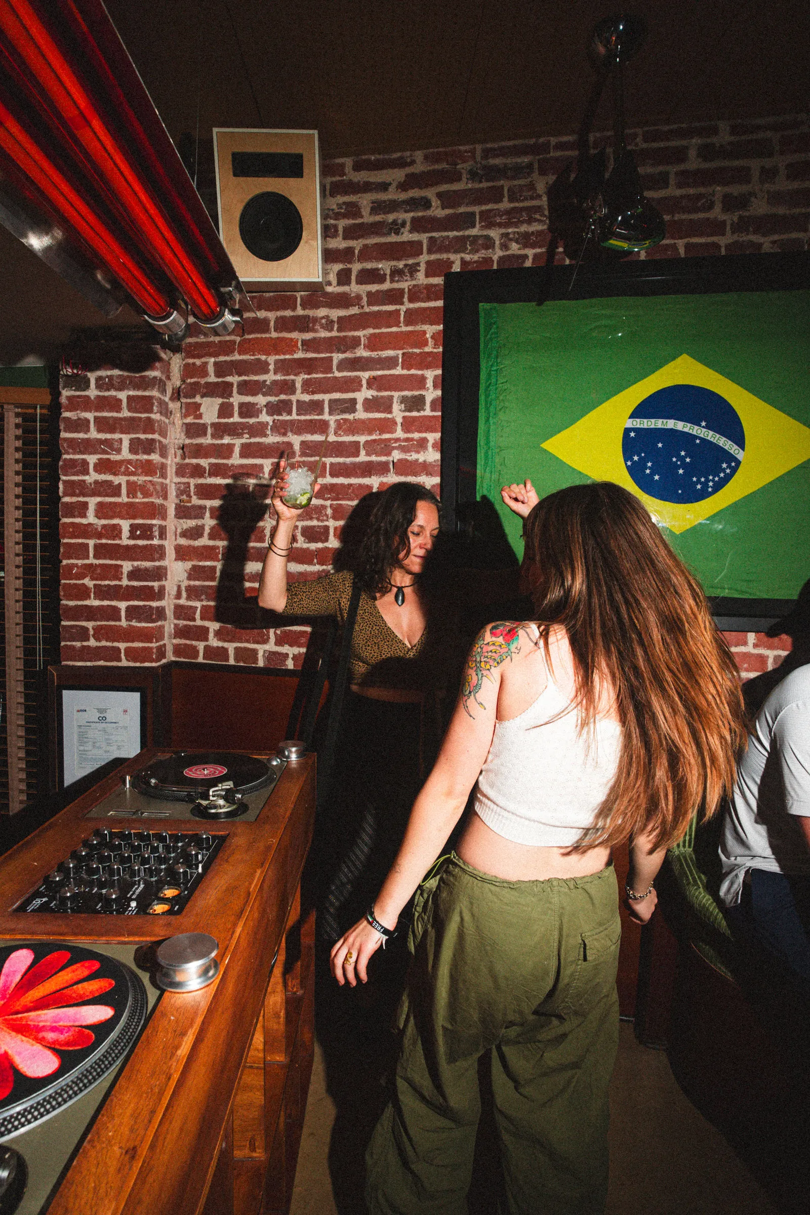 Two guests dancing beside CANA's turntables