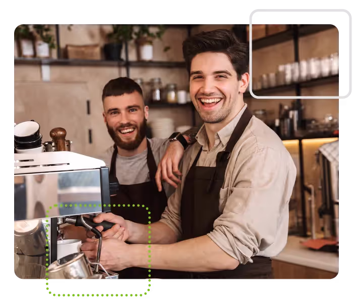 Two baristas making coffee in cafe kitchen