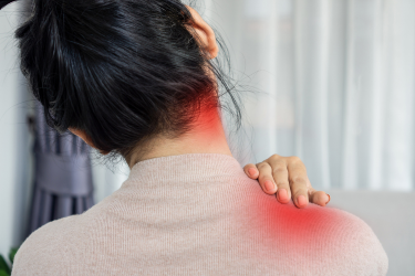 A person holds the back of their shoulder, with red overlays highlighting discomfort in the neck and shoulder.