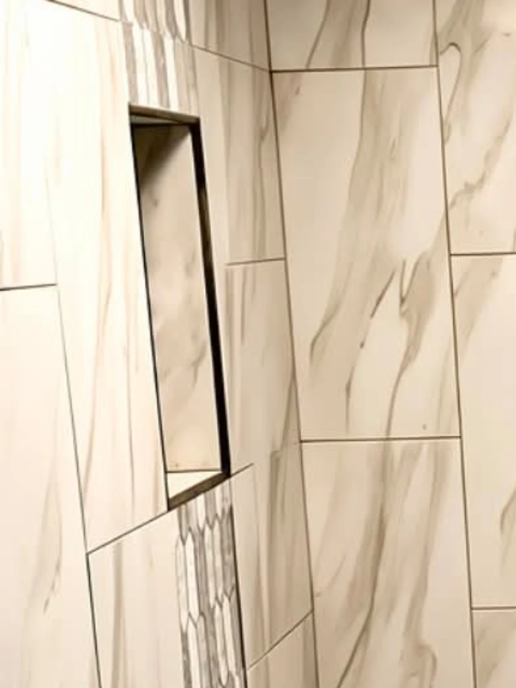 Recessed shower niche in stone-look porcelain, with veining running continuously across the joints, installed by Euphoric Tile & Design in coastal Maine