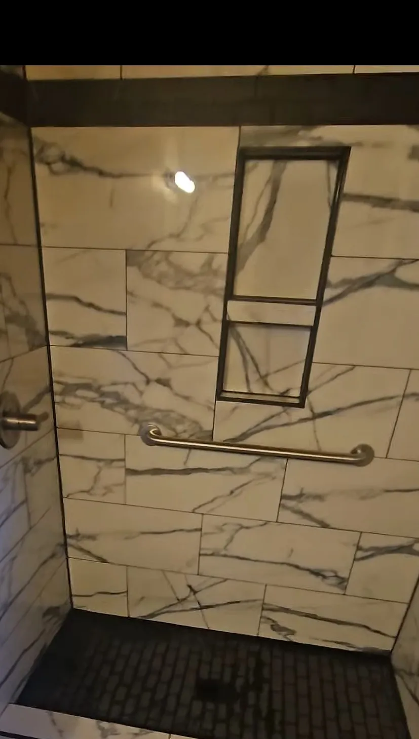 Calacatta marble shower with a grab bar set into solid blocking, installed by Euphoric Tile & Design in coastal Maine