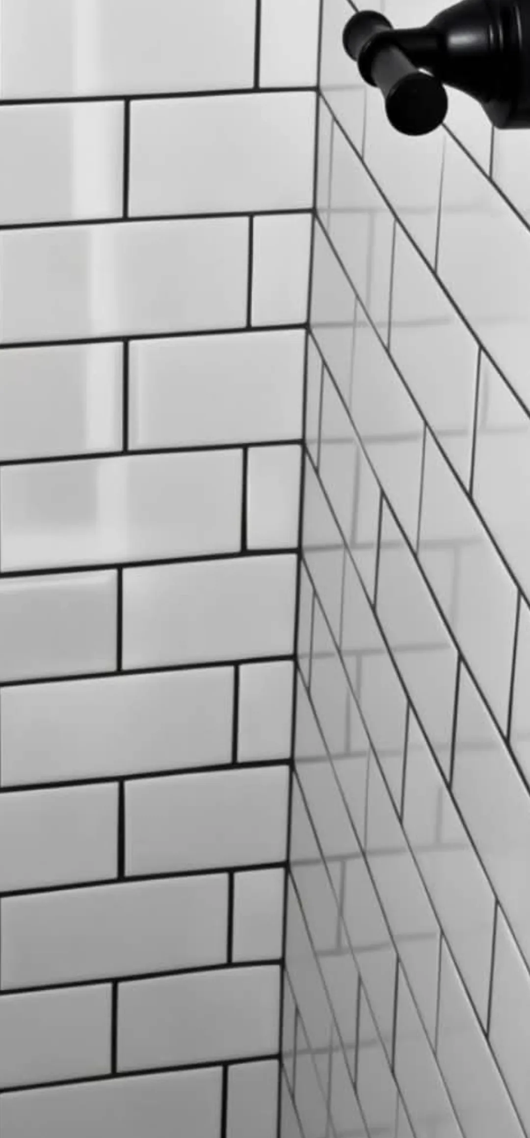White subway tile shower wall with even grout lines and black fixtures, installed by Euphoric Tile & Design in coastal Maine
