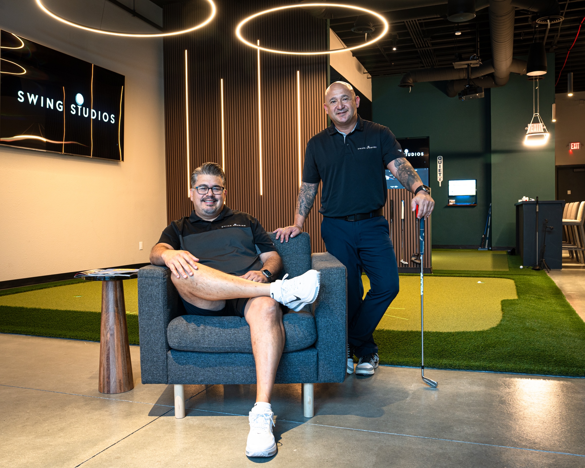 Swing Studios founders Richard Flores and Rich Ceja in the studio lounge, with the PuttView green behind them