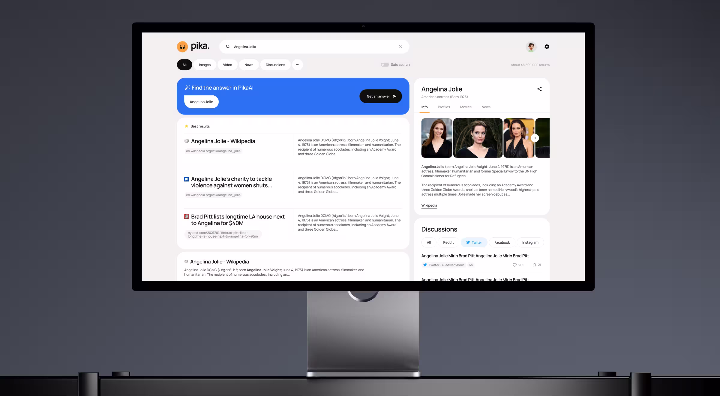 Desktop monitor displaying an AI-powered search platform with conversational search, knowledge panels, discussion feeds, and AI-assisted answer generation.
