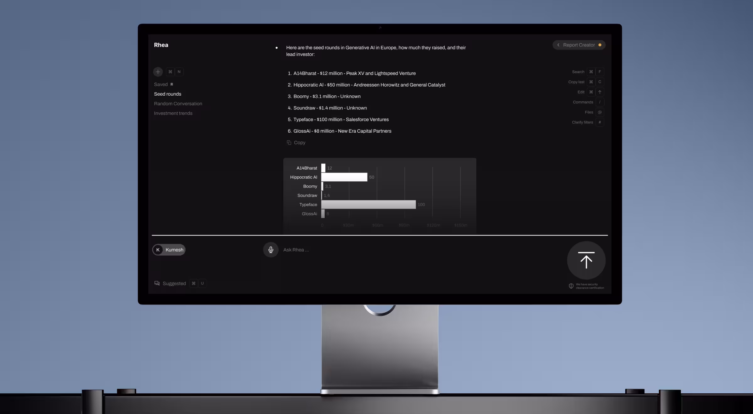 Desktop monitor displaying Rhea AI interface with a generated report on European generative AI seed rounds, including a horizontal bar chart comparing funding amounts for companies such as A14Bharat, Hippocratic AI, Boomy, Soundraw, Typeface, and Glossa. The dark UI includes navigation, command shortcuts, and an input field at the bottom for prompting Rhea