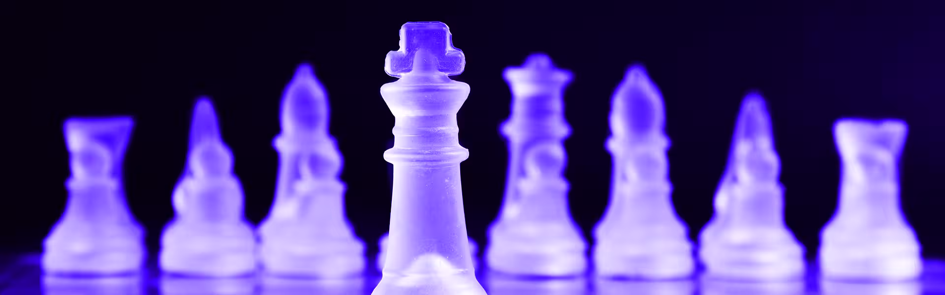 Translucent chess king standing in focus among blurred chess pieces, symbolizing strategic leadership, planning, decision-making, and competitive advantage in AI and product design.