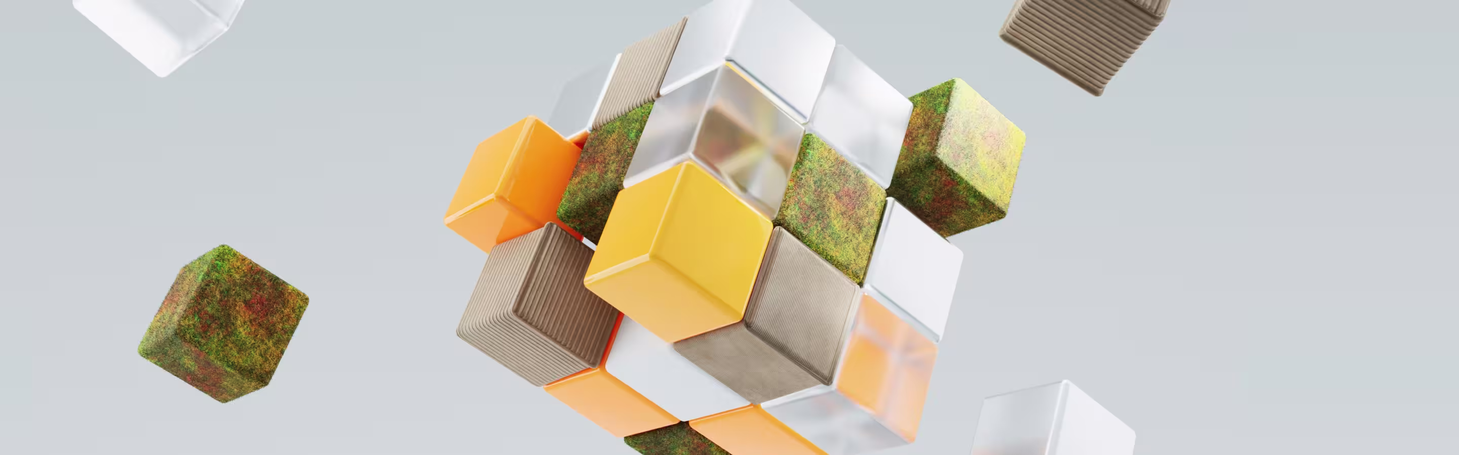 A 3D arrangement of colorful cubes—transparent, orange, textured, and moss-covered—floating against a soft gray background.