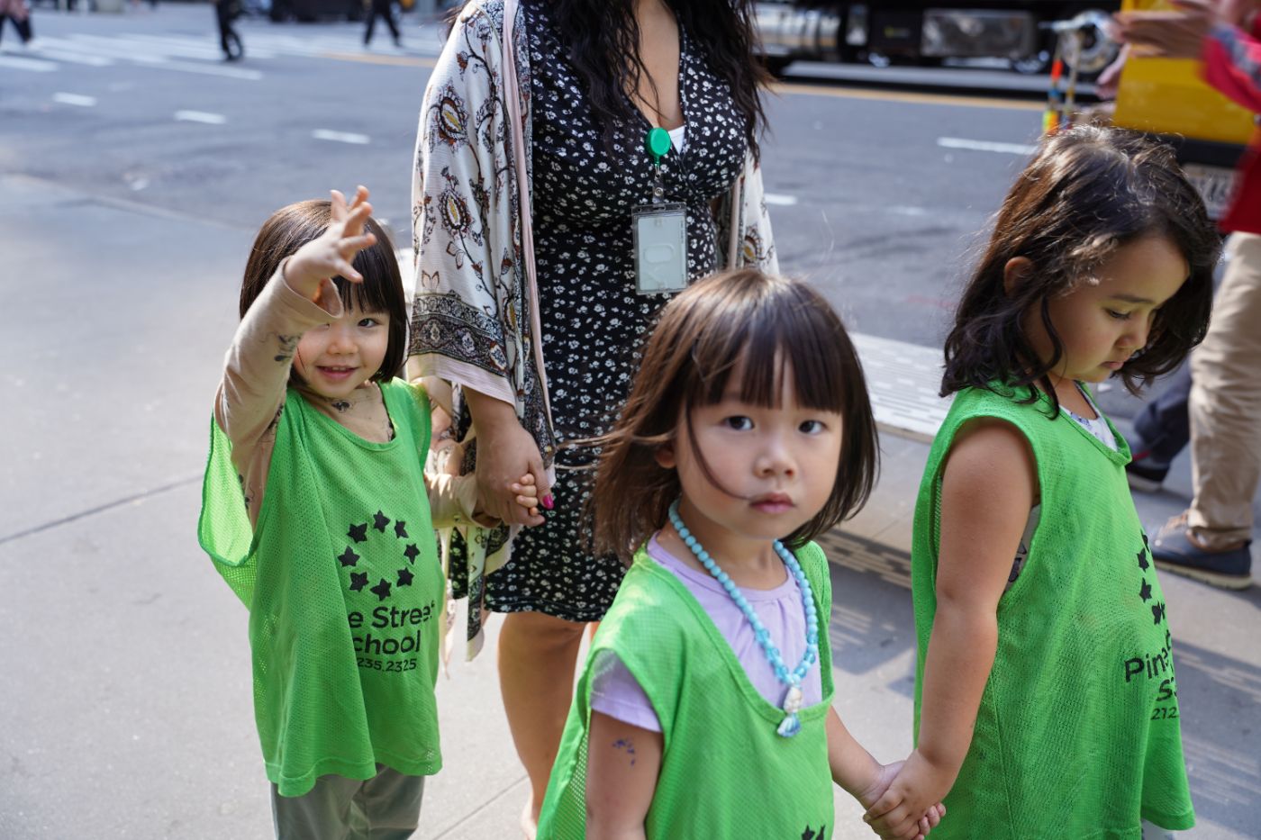 Three students and their teacher hold hands during an outdoor walk.