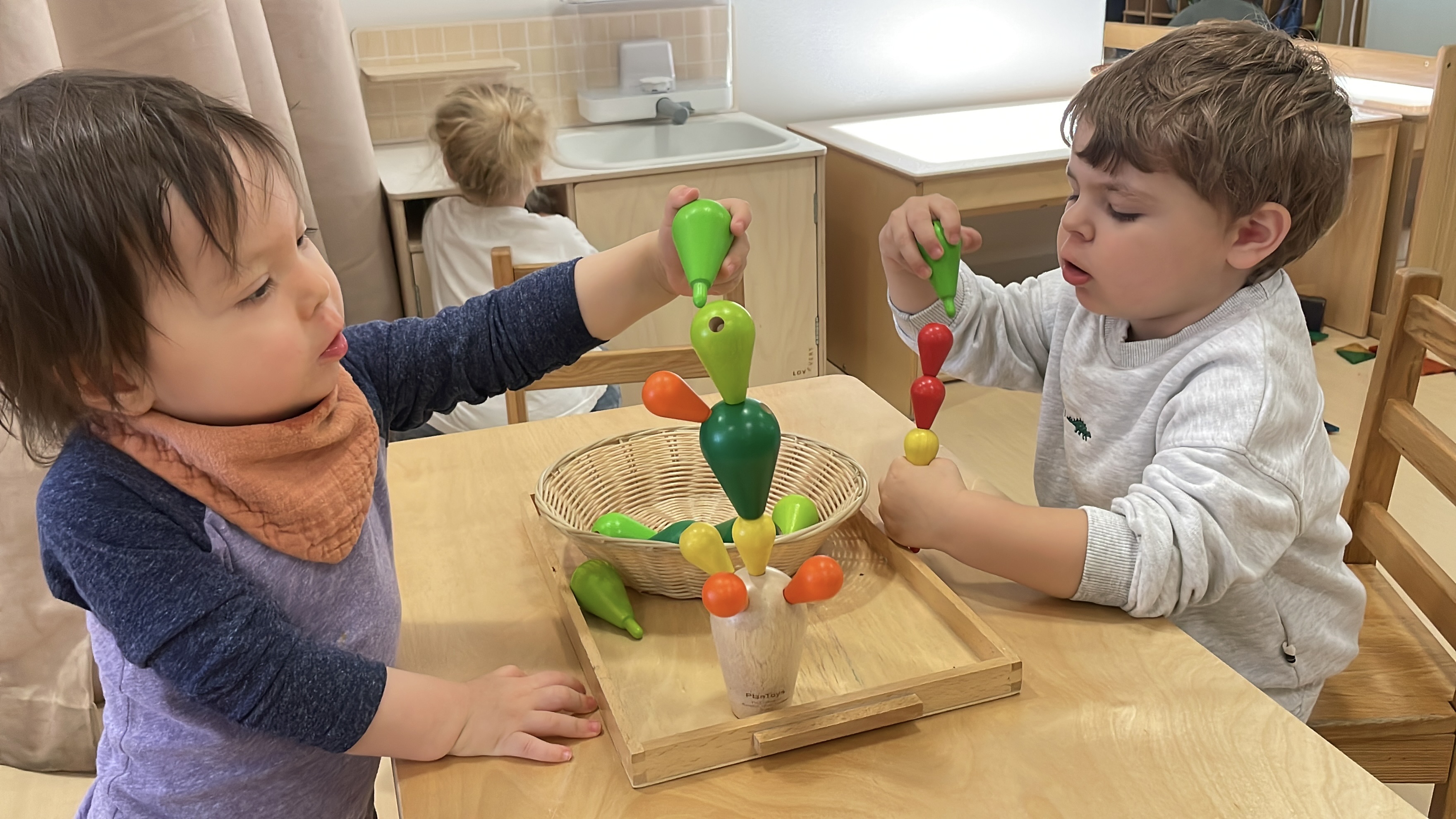 Two Pine Street School Nursery students working together to construct a wooden cactus, building fine motor skills, concentration, and collaboration.