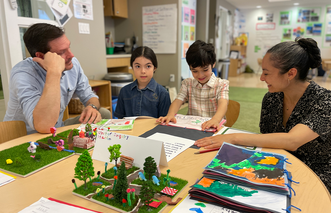 Student presenting an IB Unit of Inquiry to his family in a Pine Street School classroom.