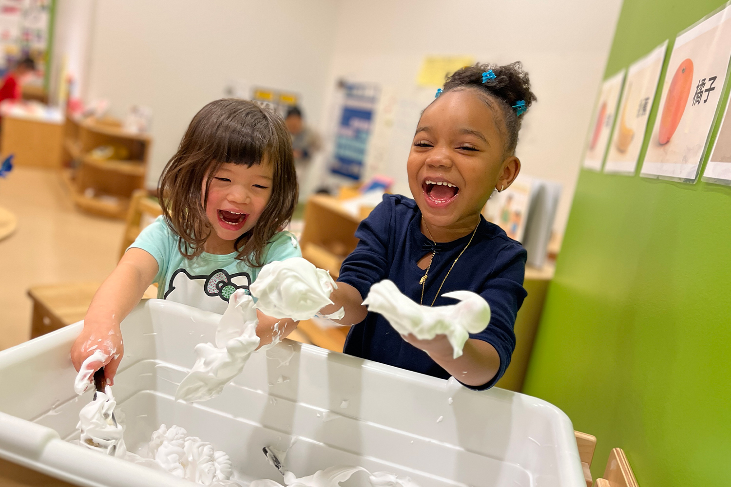 Pine Street School Preschool students exploring a sensory bin together, practicing turn-taking, cooperation, communication, and social-emotional skills through play.