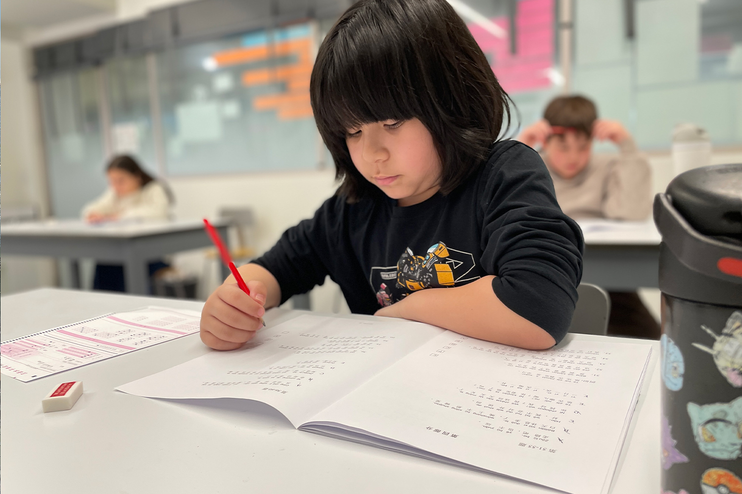 A student writing in his Mandarin workbook at Pine Street School.