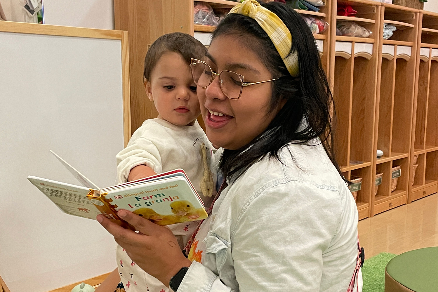 Pine Street School Early Childhood Teacher reading a book to a student in the classroom.