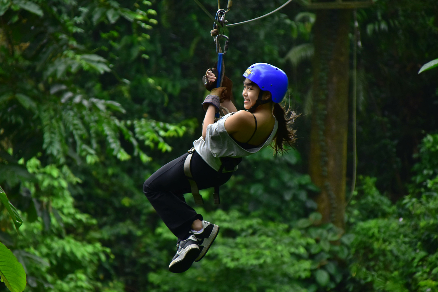 a student zip lines through a forest in Costa Rica