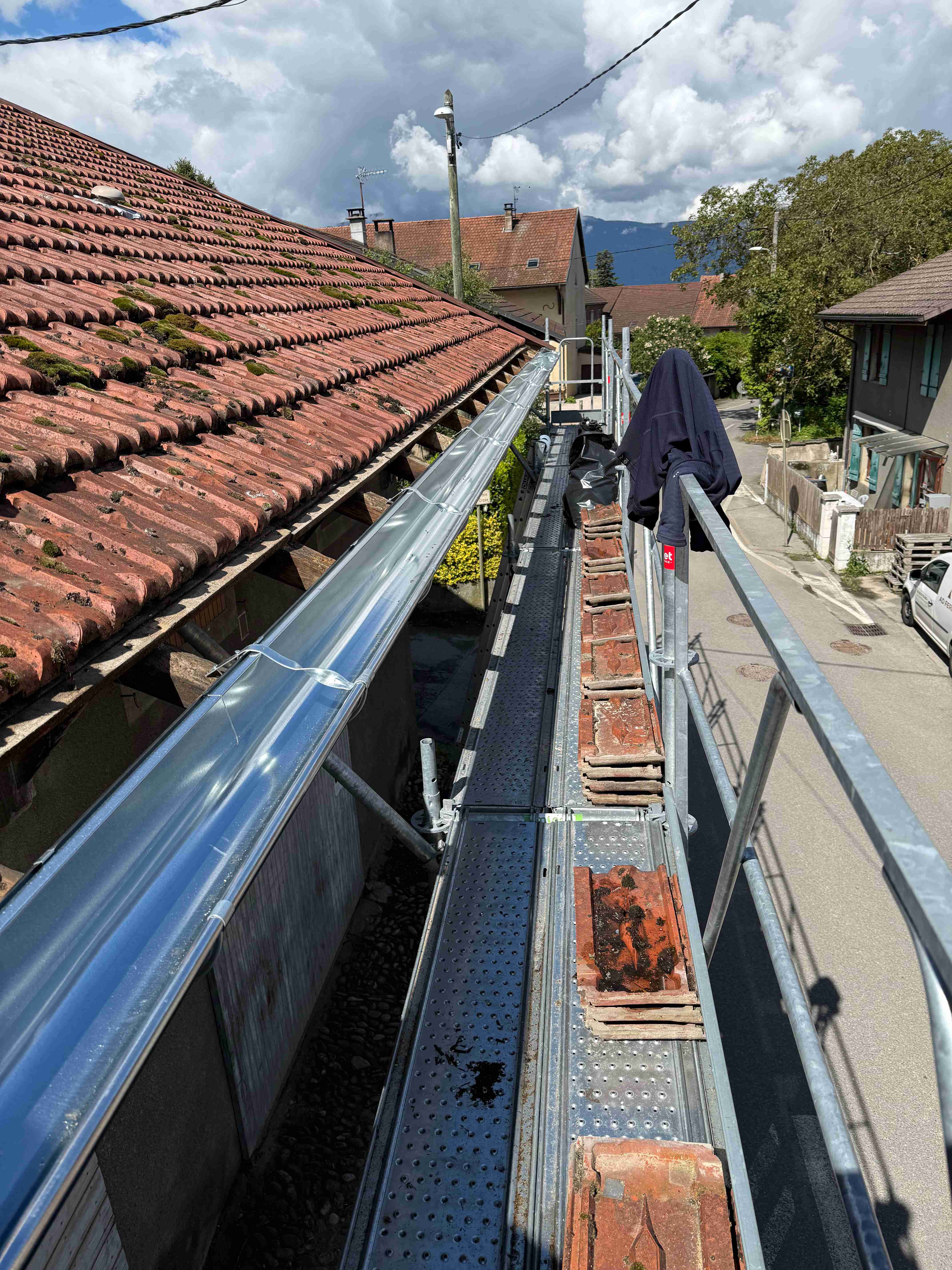 Artisan AD Ferblanterie réalisant des travaux de zinguerie sur une toiture à Feigères