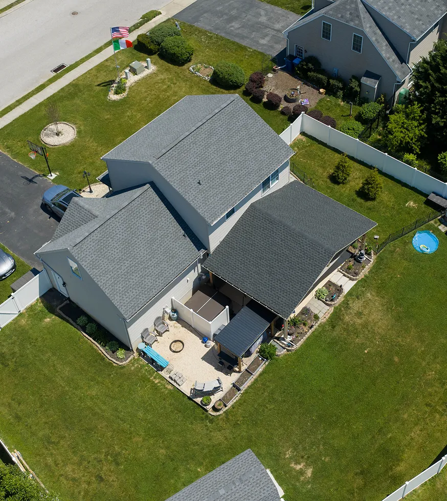 Aerial view of a suburban house with a new shingle roof.