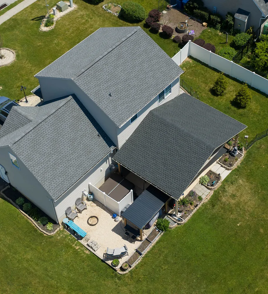 Aerial view of a suburban house with a new shingle roof.