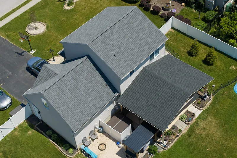 Aerial view of a suburban house with a new shingle roof.